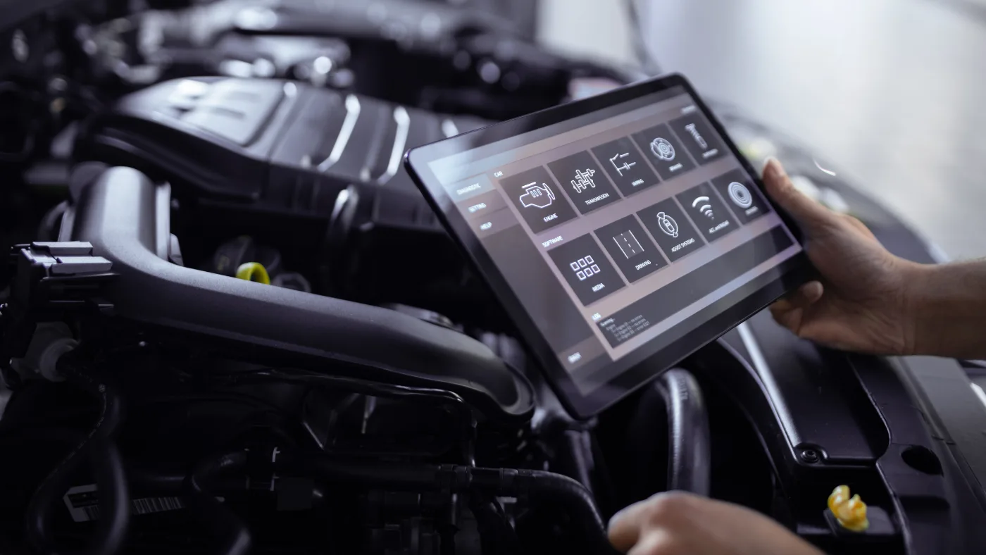 Digitale Fahrzeugdiagnose mit Tablet am Motorraum